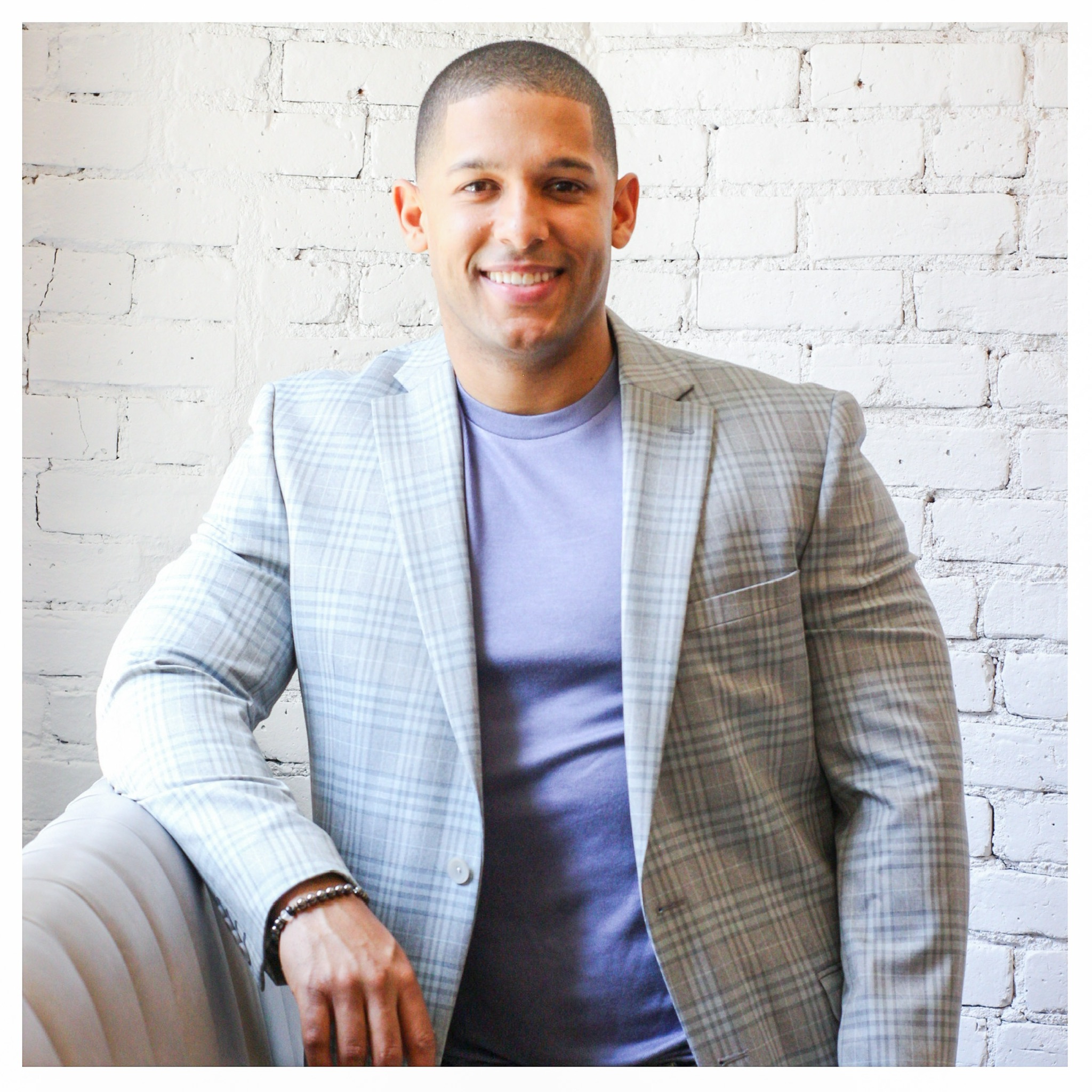 Henry Diaz smiling in a light plaid blazer